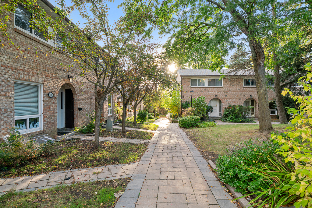 Landscaped pedestrian walkway through the complex with lawns, shrubs and shade trees